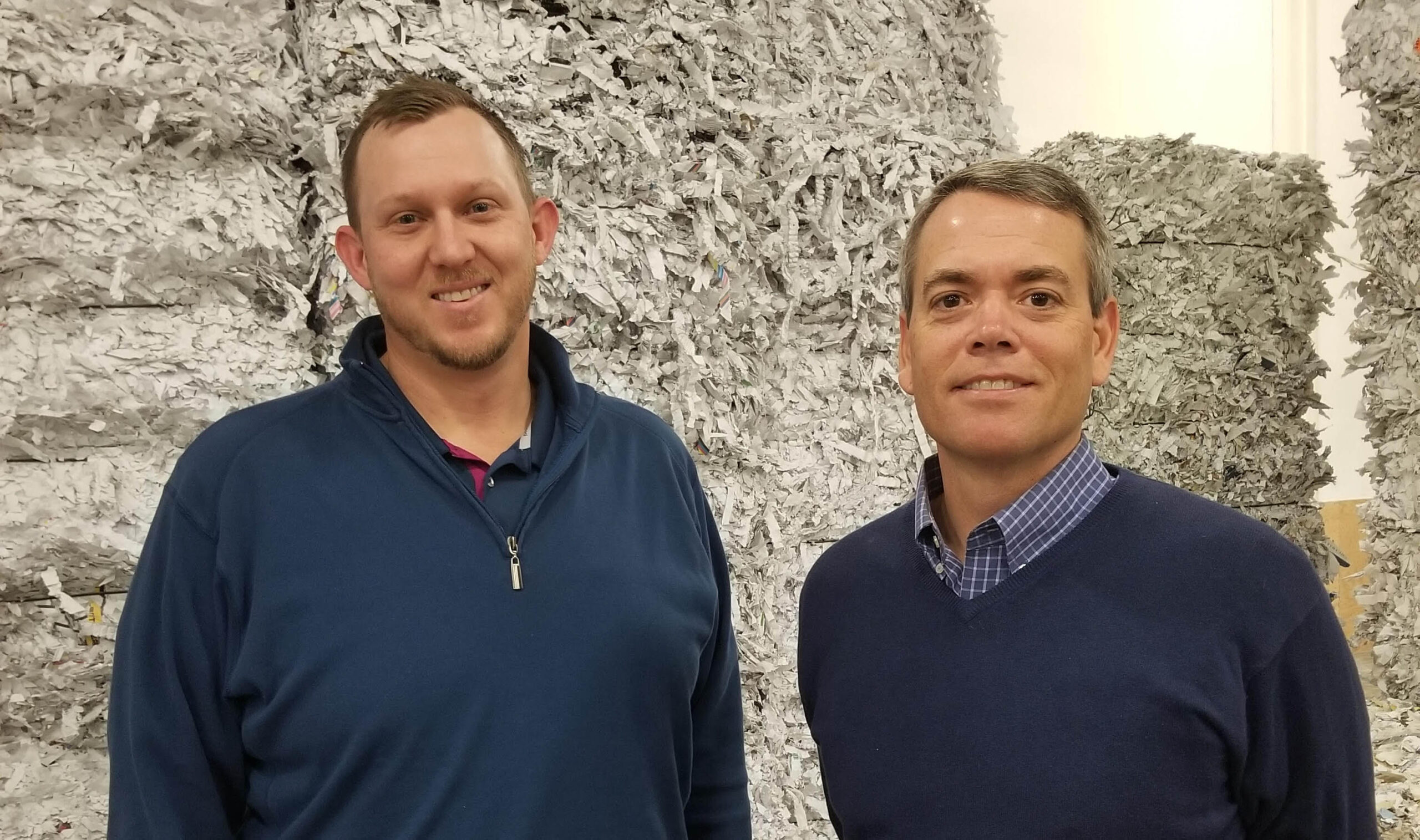 John and Rob in front of shredded paper