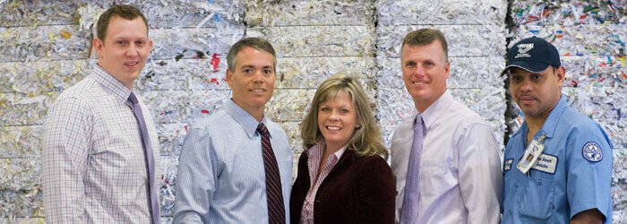 Royal Document Destruction team in front of shredded paper