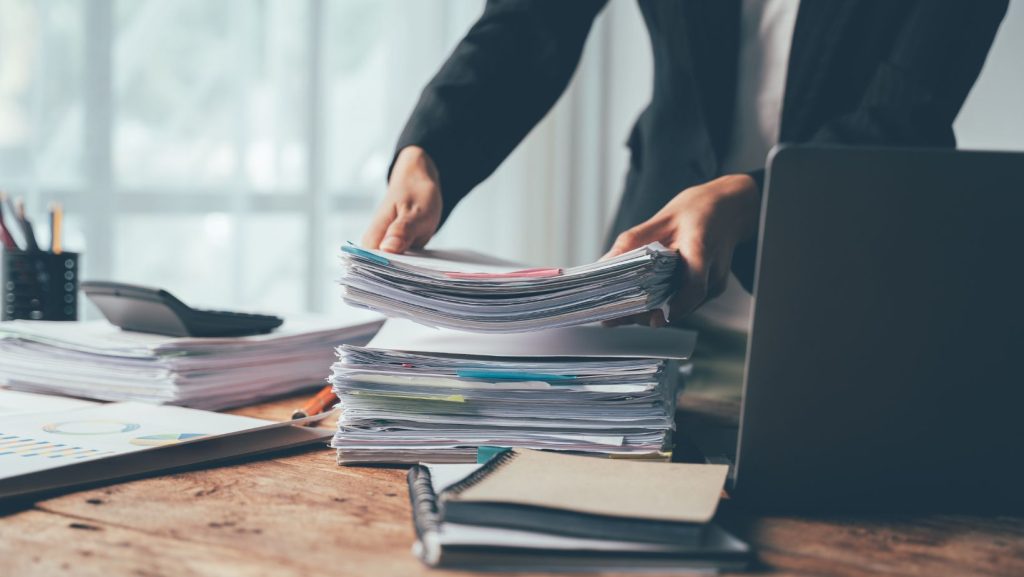 Home office worker with a stack of paperwork