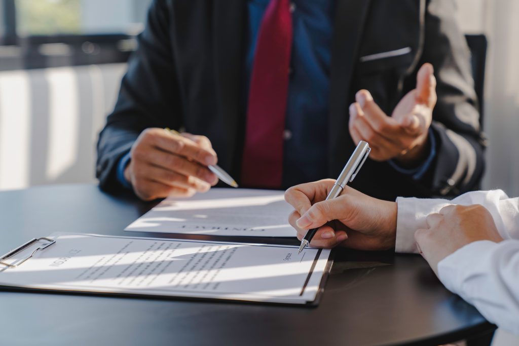 an insurance agent telling their client where to sign
