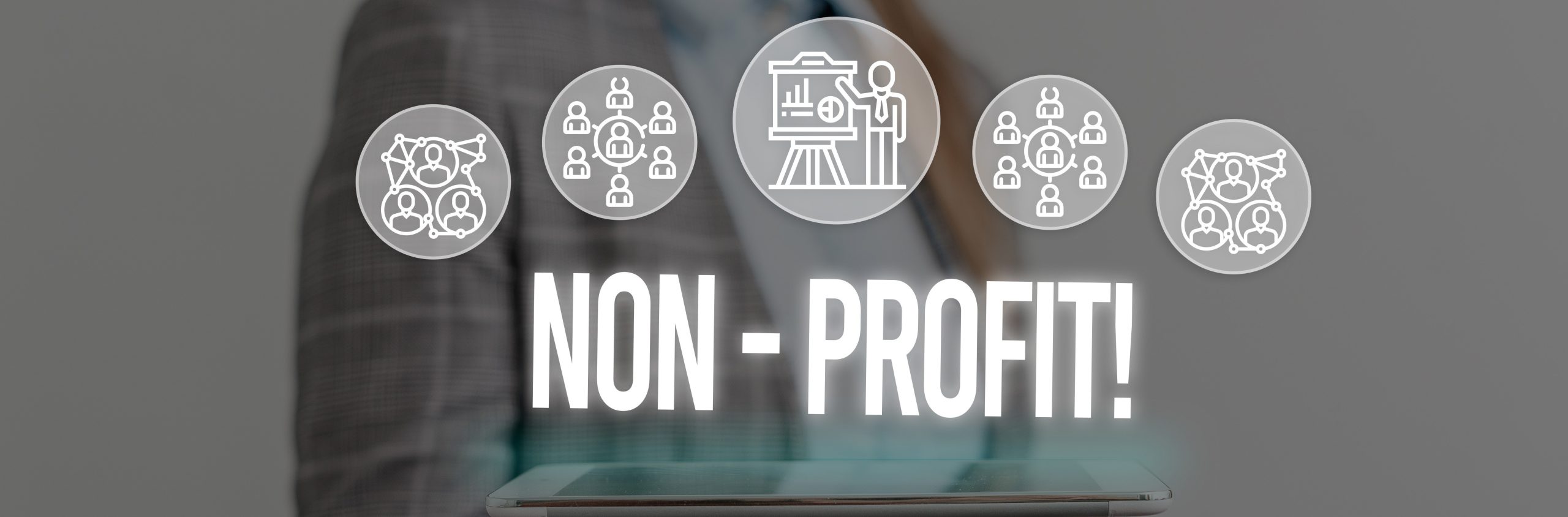Woman wear formal work suit presenting presentation using smart device with the words Non Profit above.