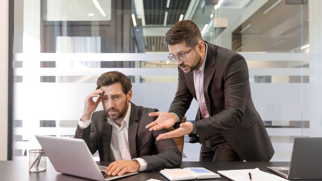 two male co-workers frustrated by costly mistake because they didn't shred old documents