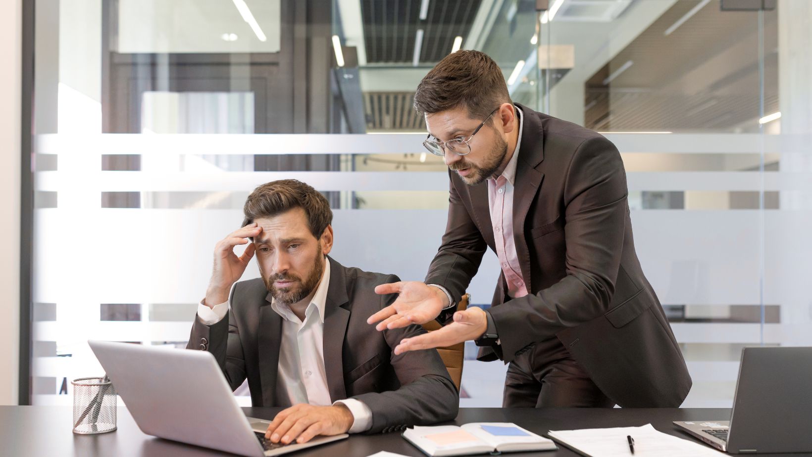 two male co-workers frustrated by costly mistake because they didn't shred old documents